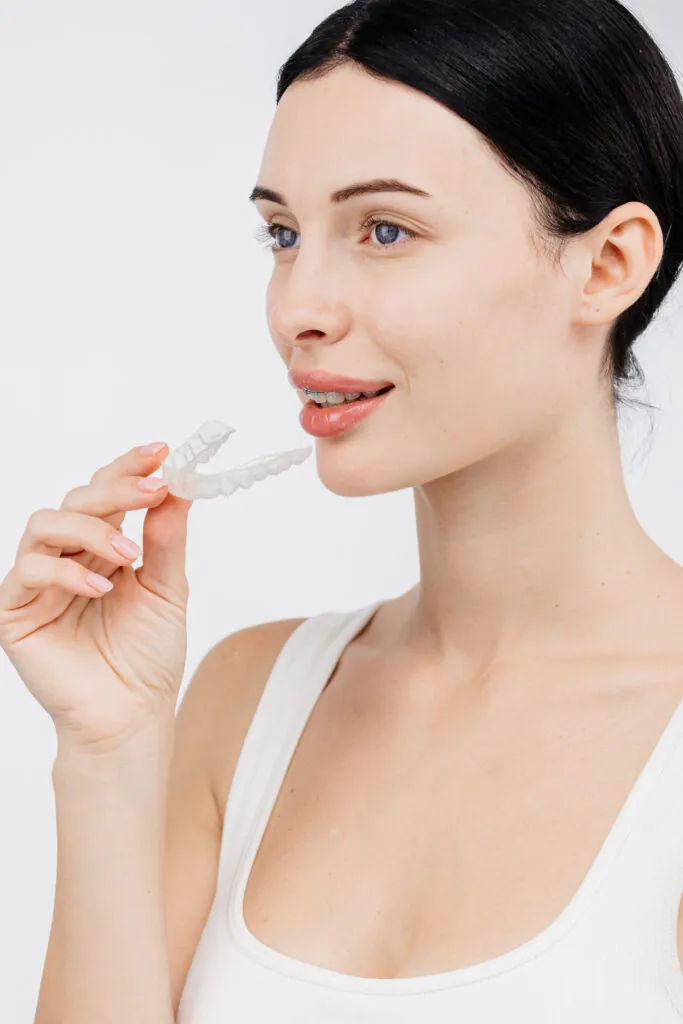 Mujer con un alineador de ortodoncia transparente. Concepto de corrección dental y sonrisa hermosa.