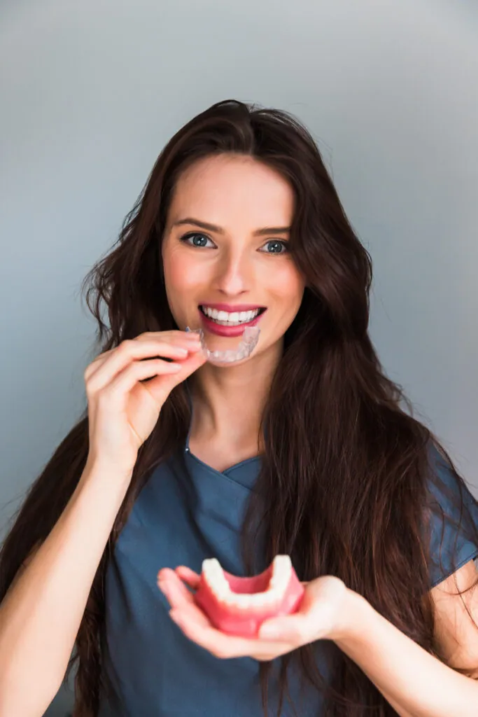 Frenillos o alineadores Invisalign. El dentista explica cómo la ortodoncia invisible logra dientes hermosos en la clínica dental.